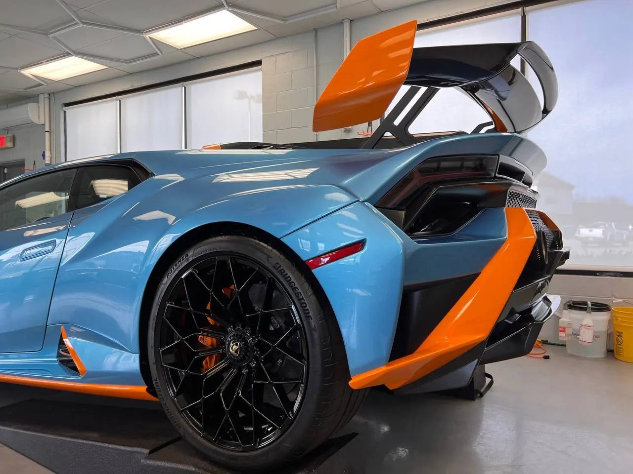 Blue and orange Lamborghini Huracán STO in the install bay