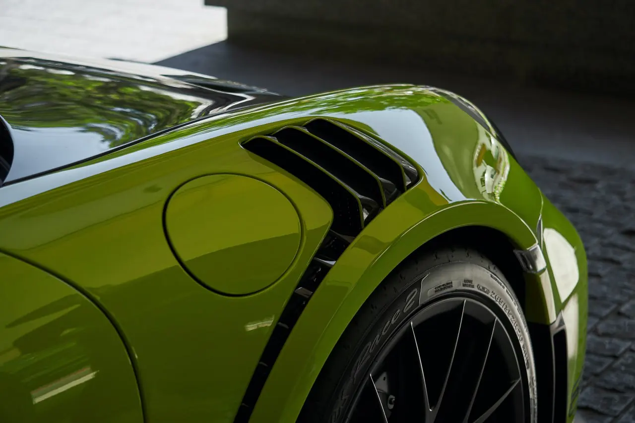 Rear wheel arch of a lime green Porsche 911 GT3 RS, film edge invisible against the paint