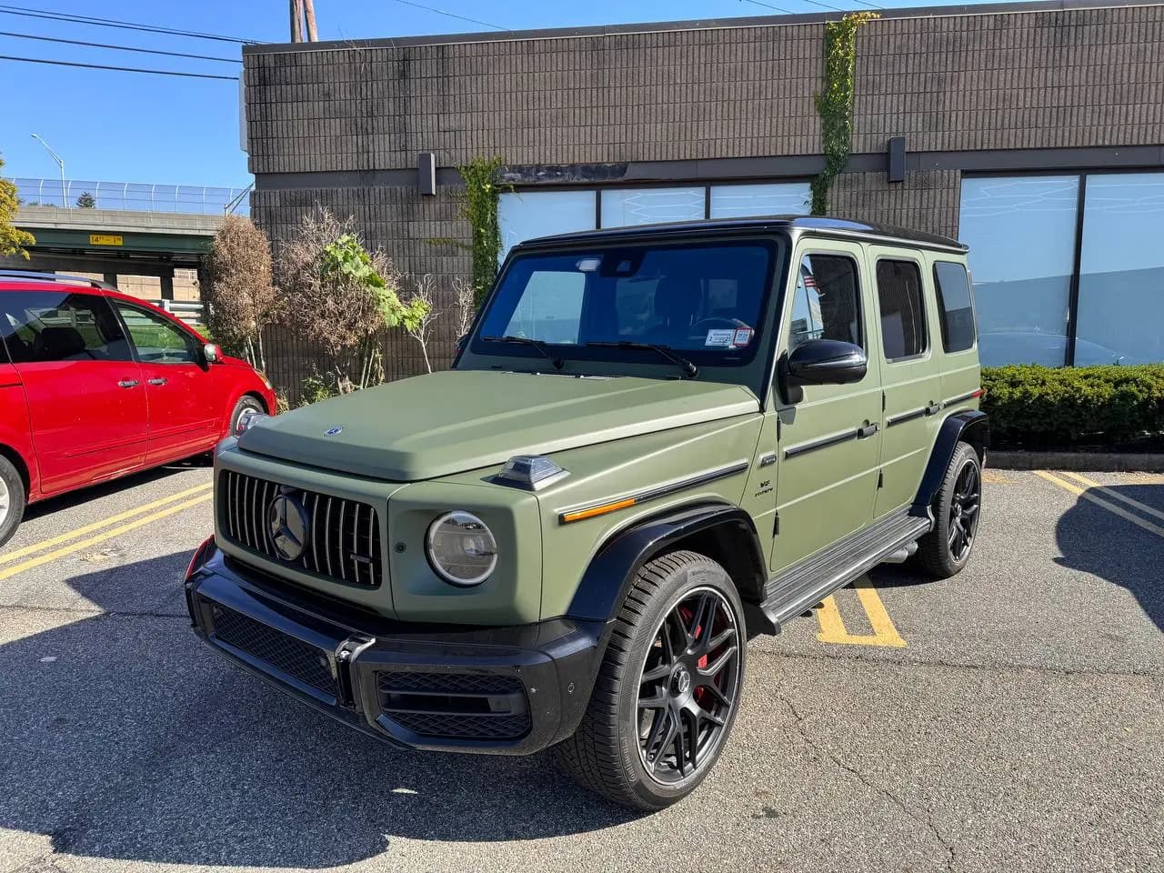 Matte green Mercedes-AMG G 63 parked outside the shop