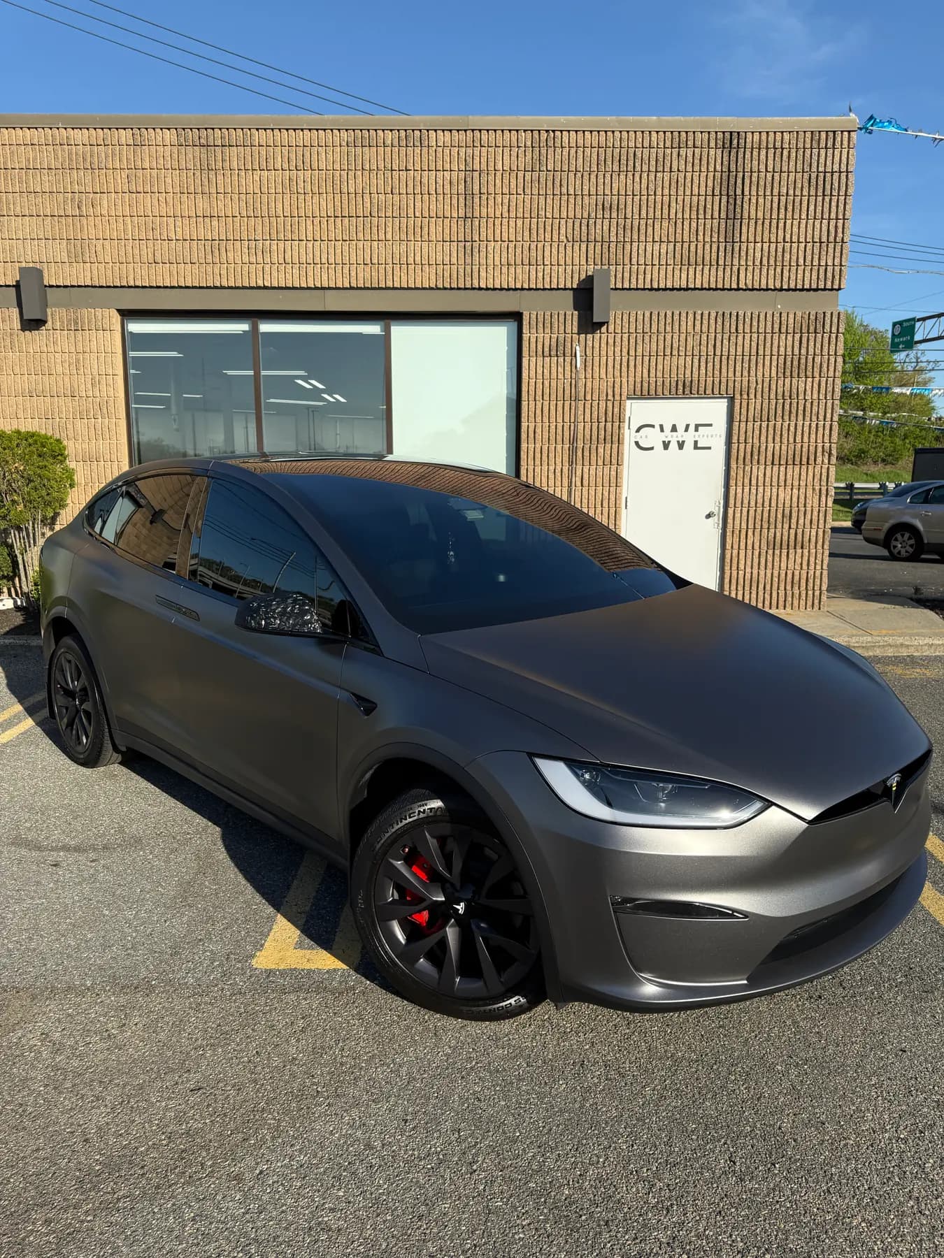 Matte grey Tesla Model X parked outside the shop